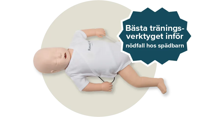 Resusci Baby QCPR docka med en vit jumpsuit. Etikett: Bästa träningsverktyget inför nödfall hos spädbarn. 