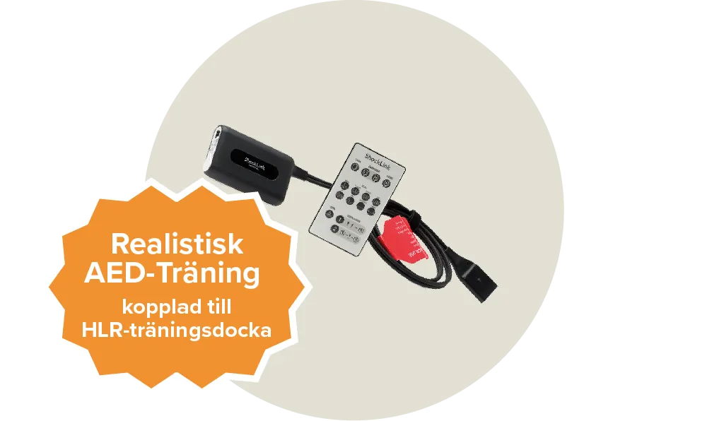En svart sladd och en vit fjärrkontroll från märket Shocklink. Etikett: Realistisk AED-träning, kopplad till HLR-träningsdocka.